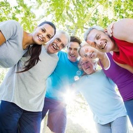 Sechs Menschen in Sportkleidung stehen unter einem Baum im Kreis und haben sich die Arme um die Schultern gelegt.