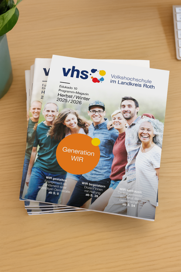 Ein Stapel der Programm-Magazine Edukado 10 liegt auf einem Schreibtisch